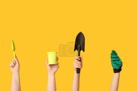 Téléchargez les photos : Mains féminines avec outils de jardinage sur fond jaune - en image libre de droit
