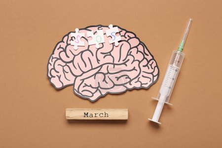Paper brain with puzzle pieces, syringe and word MARCH on brown background. Multiple Sclerosis Awareness Month