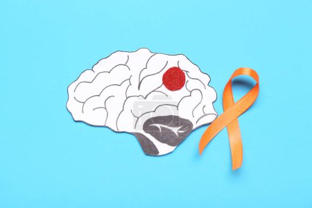 Paper brain and orange ribbon on blue background. Multiple Sclerosis Awareness Month