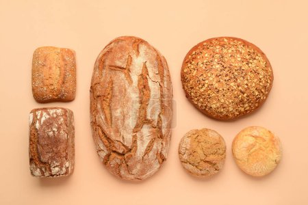 Photo for Loaves of fresh bread and buns on beige background - Royalty Free Image