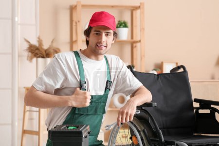 Junger Arbeiter repariert Rollstuhl zu Hause