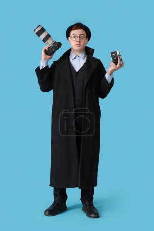 Männlicher Spion mit Fotokameras auf blauem Hintergrund