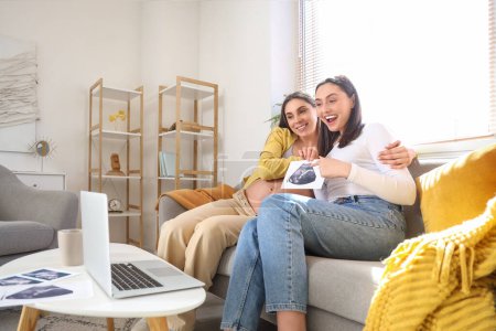 Joven embarazada lesbiana pareja con ecografía imagen vídeo chat en casa