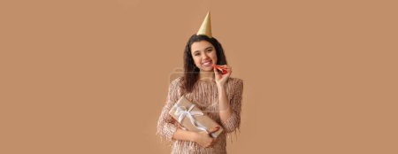 Téléchargez les photos : Belle femme célébrant son anniversaire sur fond brun - en image libre de droit