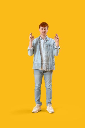Photo for Young redhead man crossing fingers on yellow background - Royalty Free Image