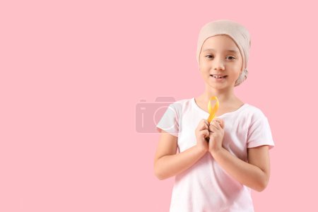 Téléchargez les photos : Petite fille asiatique après chimiothérapie avec ruban sur fond rose. Concept de sensibilisation au cancer chez l'enfant - en image libre de droit