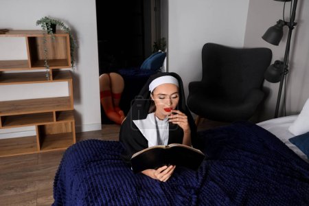 Sexy monja con la Santa Biblia rezando en el dormitorio