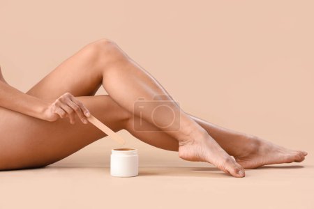 Photo for Beautiful young woman with sugaring paste on beige background - Royalty Free Image