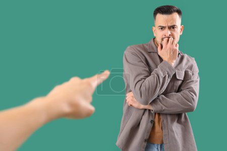 Photo for Woman pointing at worried young man on green background. Accusation concept - Royalty Free Image