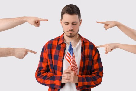 Photo for People pointing at young man with USA flag on white background. Accusation concept - Royalty Free Image