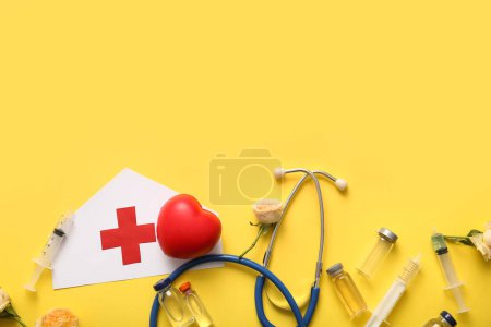 Paper medical hat with stethoscope, ampules and roses for International Nurses Day on yellow background