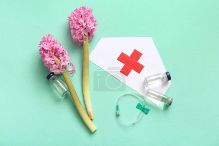 Photo for Paper medical hat with flowers, ampules and catheter for International Nurses Day on turquoise background - Royalty Free Image