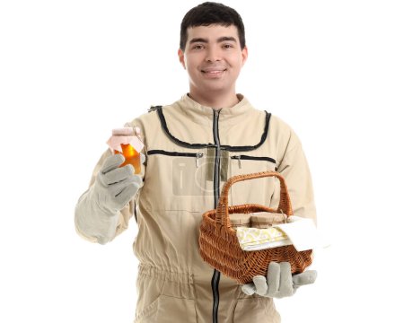 Male beekeeper with honey and basket on white background