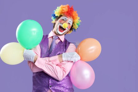 Foto de Retrato de payaso con globos sobre fondo lila. Celebración del día del tonto de abril - Imagen libre de derechos