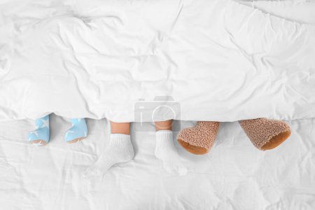 Photo for Feet of cute little boy and his toys sleeping in bedroom - Royalty Free Image
