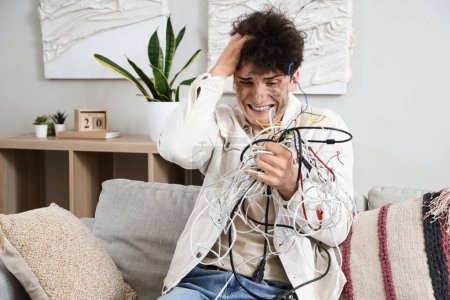 Hombre joven electrocutado con cara de quemadura y cables en casa