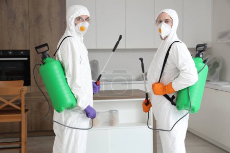 Foto de Trabajadores masculinos con desinfectante en cocina - Imagen libre de derechos