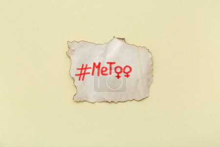Téléchargez les photos : Pièce en papier brûlé avec hashtag METOO et symboles de genre de la femme sur fond jaune - en image libre de droit