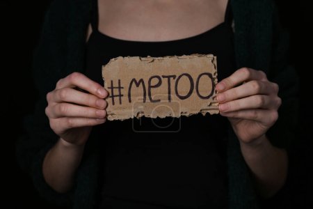 Téléchargez les photos : Femme tenant du papier cartonné avec hashtag METOO sur fond sombre, gros plan - en image libre de droit