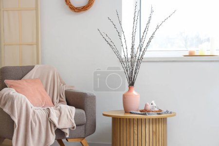 Téléchargez les photos : Vase rose avec branches de saule sur la table dans le salon intérieur - en image libre de droit