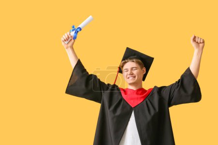 Photo for Happy male graduate with diploma on yellow background - Royalty Free Image