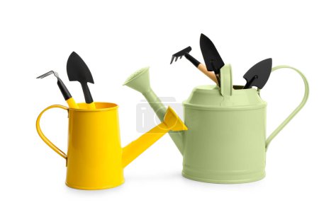 Watering cans with gardening supplies on white background