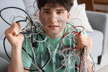 Hombre joven electrocutado con cara de quemadura y cables en casa, primer plano