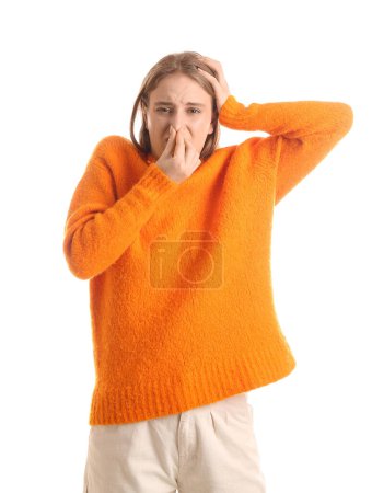 Mujer joven pellizcando la nariz debido a olor repugnante sobre fondo blanco