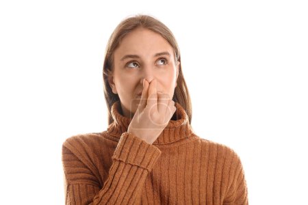 Young woman feeling bad smell on white background