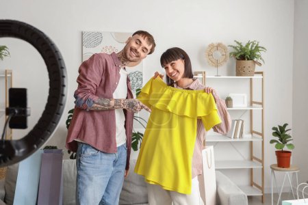 Téléchargez les photos : Couple de blogueurs de mode avec des vêtements enregistrement vidéo à la maison - en image libre de droit