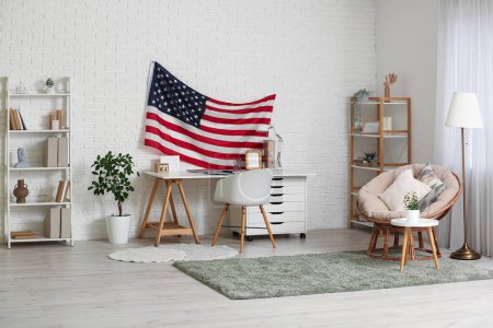 Téléchargez les photos : Intérieur du salon moderne avec drapeau américain suspendu au-dessus d'un espace de travail confortable - en image libre de droit