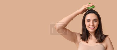 Photo for Beautiful young woman using scalp massager on beige background with space for text - Royalty Free Image