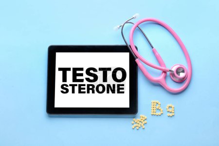 Téléchargez les photos : Tablette avec mot TESTOSTERONE à l'écran, stéthoscope et texte B9 en pilules d'acide folique sur fond bleu clair - en image libre de droit
