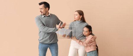 Man leaving his family on beige background. Divorce concept