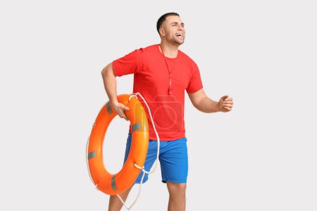 Photo for Happy young lifeguard with lifebuoy running on white background - Royalty Free Image