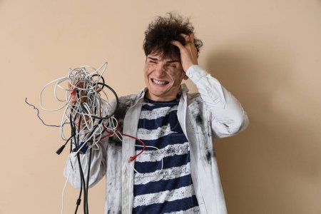 Electrocuted young man with burnt face on beige background