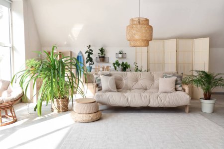 Téléchargez les photos : Intérieur du salon lumineux avec canapé et plantes tropicales - en image libre de droit