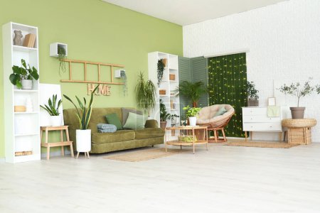 Téléchargez les photos : Intérieur du salon avec plantes vertes, canapé et lumières incandescentes - en image libre de droit