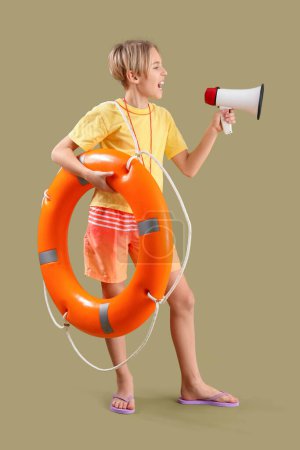 Photo for Happy little boy lifeguard with ring buoy and megaphone on green background - Royalty Free Image