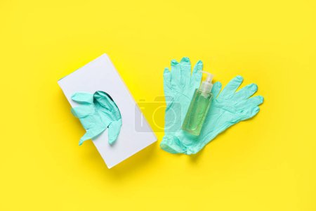 Flasche Desinfektionsmittel und Gummihandschuhe Pack auf gelbem Hintergrund