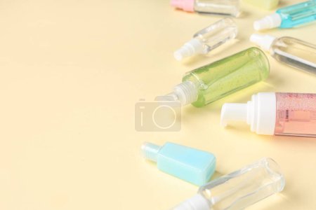 Viele verschiedene Flaschen Desinfektionsmittel auf blassgelbem Hintergrund