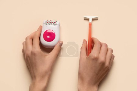 Photo for Female hands with modern epilator and razor on beige background - Royalty Free Image