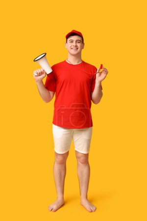 Male lifeguard with megaphone and whistle on yellow background