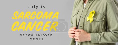 Photo for Woman with yellow ribbon on grey background. Banner for Sarcoma Cancer Awareness Month - Royalty Free Image