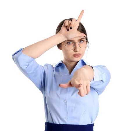 Photo for Young businesswoman showing loser gesture and pointing at viewer on white background - Royalty Free Image