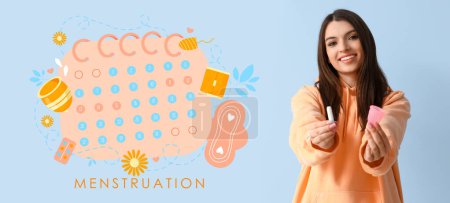 Photo for Young woman holding tampon with silicone cup and drawn menstrual calendar on blue background - Royalty Free Image