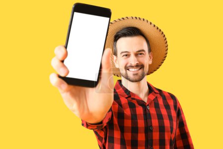 Homme heureux avec téléphone portable sur fond jaune. Bannière pour le design