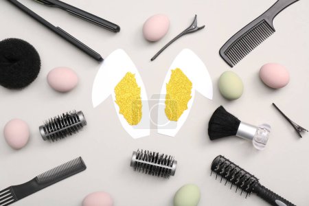 Photo for Paper bunny ears with Easter eggs and hairdressing accessories on white background - Royalty Free Image