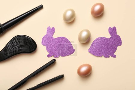 Photo for Hairdressing accessories with Easter eggs and bunnies on beige background - Royalty Free Image