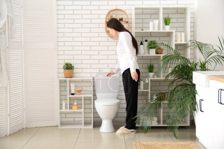 Téléchargez les photos : Jeune femme d'affaires chasse d'eau toilettes dans les toilettes - en image libre de droit
